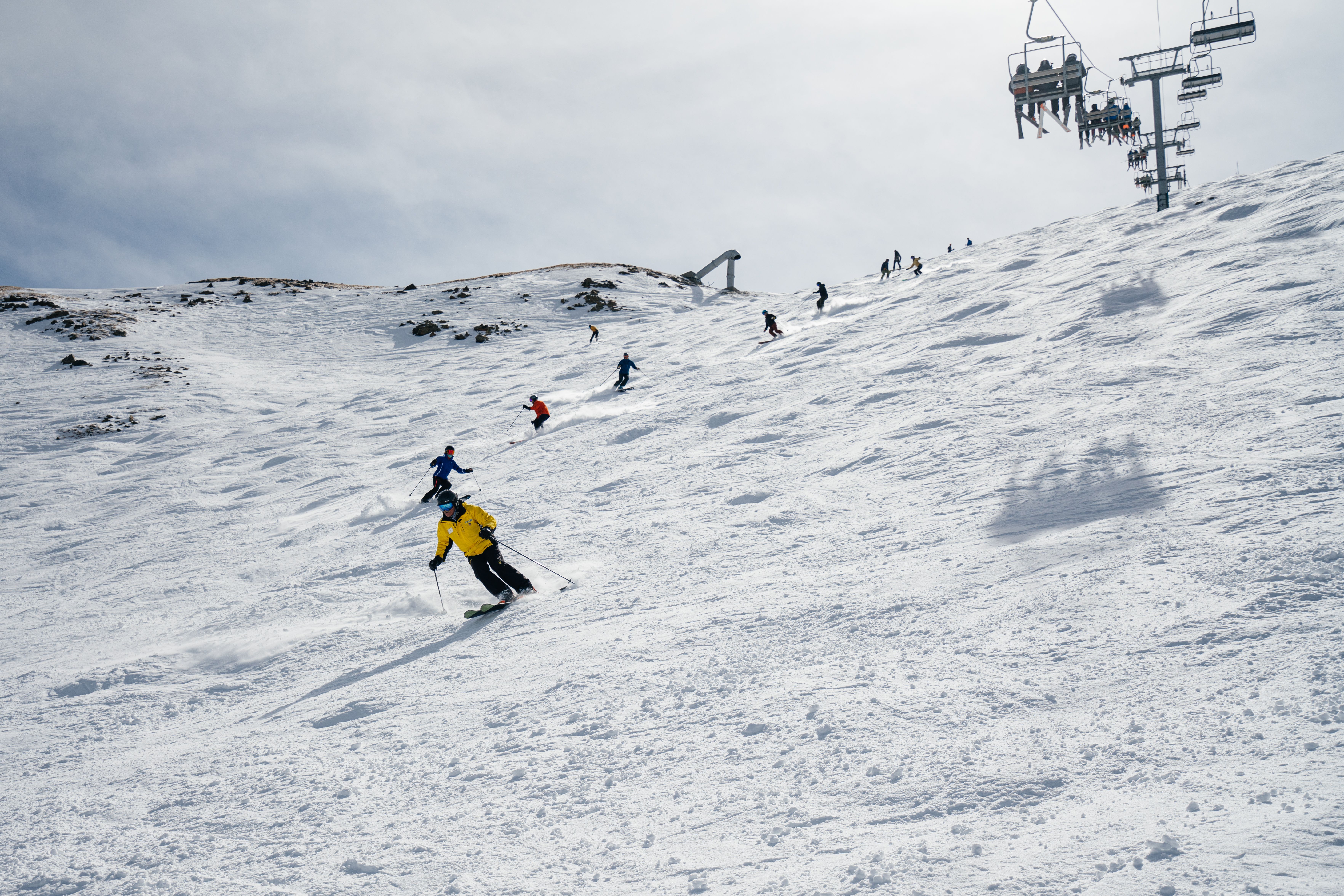 A class of skiers follow a ski instructor down steep terrain at Taos Ski Valley.